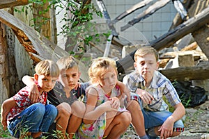 Children are near the ruined house, the concept of natural disaster, fire, and devastation.