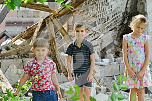 Children are near the ruined house, the concept of natural disaster, fire, and devastation.