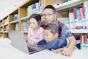 Children observing their dad teaching in library