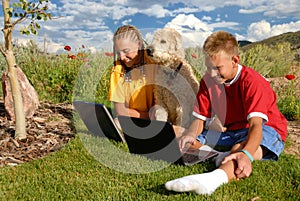 Children outdoors with laptops