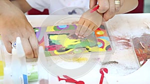 Children painting with colored sand