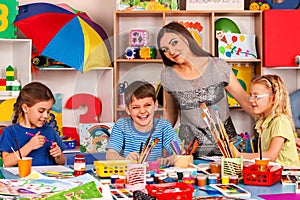 Children painting and drawing together . Craft lesson in primary school.