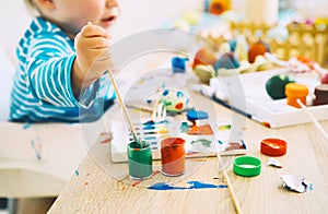 Children painting eggs. Family preparing for Easter