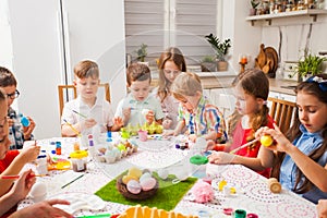 Children painting eggs. Happy family preparing for Easter.