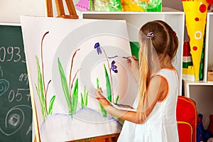 Children painting finger on easel. Group of kids with teacher.