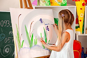 Children painting finger on easel. Group of kids with teacher.