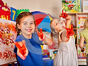 Children painting finger on easel. Small students in art school class.