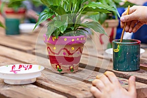 Children are painting potted plants made of pottery close up