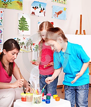 Children painting with teacher.