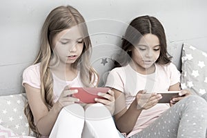 Children in pajama interact with smartphones. Application for kids fun. Internet surfing and absence parental advisory