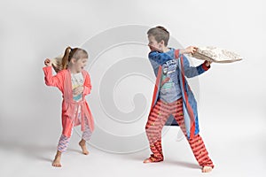 Children in pajamas staged a pillow fight on a white background