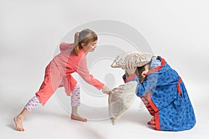 Children in pajamas staged a pillow fight on a white background