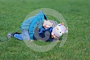 Children palying, having fun, lying on the grass, laughing