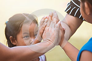 Children and parent holding hands and playing together