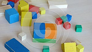 Children and parent playing together with wooden bricks