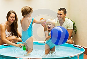 Children and parents playing in pool