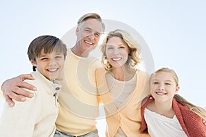 Children And Parents Smiling Against Clear Blue Sky