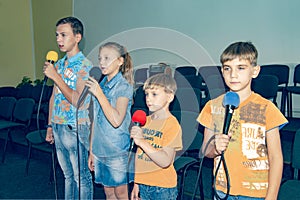 Children participate with a microphone, recite poems, recitation