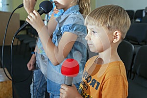 Children participate with a microphone, recite poems, recitation