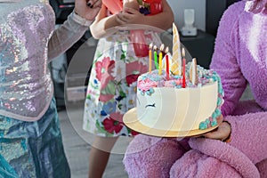 Children party entertainer gives tasty bright cake decorated in form of fantasy unicorn for kid celebrating birthday with friends