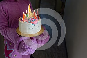 Children party entertainer gives tasty bright cake decorated in form of fantasy unicorn for kid celebrating birthday with friends