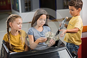 Children paying money at gas station.