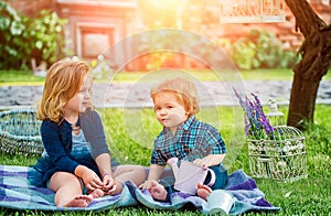 Children on pirnic. Baby playing in green grass. Child having fun on family picnic in summer garden. Brother and sister