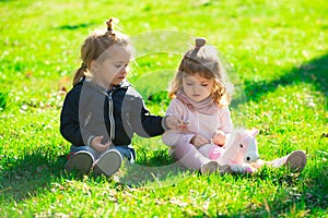 Children on pirnic. Cute boy and girl sit on grass on summer field. Happy baby children playing on green grass in spring