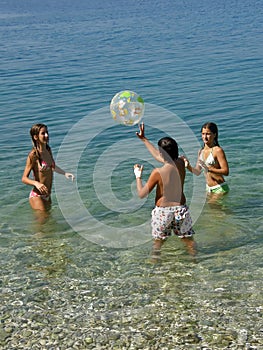 Children play with a ball in sea