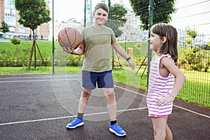 Children play basketball on a city playground.  Streetball basketball game with two players, outdoor city basketball court