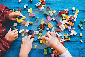 Children play and build with colorful toy bricks, plastic blocks