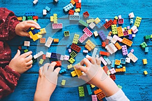 Children play and build with colorful toy bricks, plastic blocks photo
