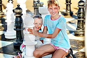 Children play chess outdoor.