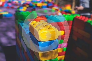 Children play colorful big toy blocks in kindergarten day care center playground, kids playing with various plastic mega