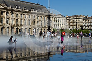 Children play and enjoy on the Water Mirror in the Place de la Bourse. Bordeaux.