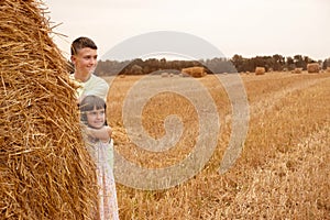 Children play in the field with a haystack. Children in nature. Family weekend lifestyle