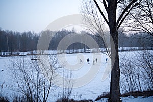 Children play ice hockey on a frozen lake