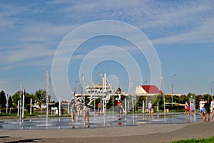 Children play with jets of a fountain on a hot sunny afternoon in the park of the 50th anniversary of JSC AvtoVAZ.