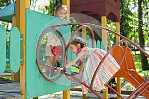 Children play in the playground. Amusement park. Leisure activities of little friends in the park.