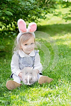 Children play with real rabbit. Laughing child at Easter egg hunt with pet bunny