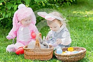 Children play with real rabbit. Laughing child at Easter egg hunt with pet bunny
