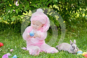 Children play with real rabbit. Laughing child at Easter egg hunt with pet bunny