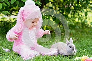 Children play with real rabbit. Laughing child at Easter egg hunt with pet bunny