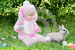 Children play with real rabbit. Laughing child at Easter egg hunt with pet bunny