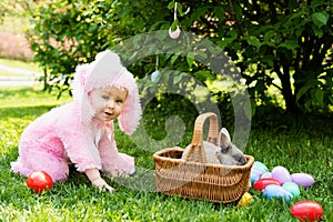 Children play with real rabbit. Laughing child at Easter egg hunt with pet bunny.