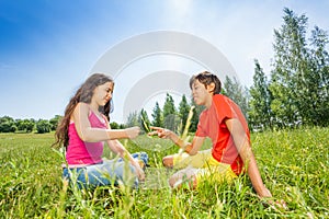 Children play rock-paper-scissors on grass