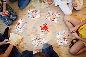 Children play Russian lotto sitting on floor, photo