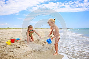 Children play with sand on beach