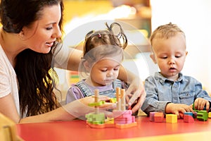 Children play with shapes and colorful wooden puzzle in a montessori classroom