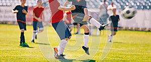 Children Play Soccer Game. Young Boys Running and Kicking Football Ball on Grass Sports Field